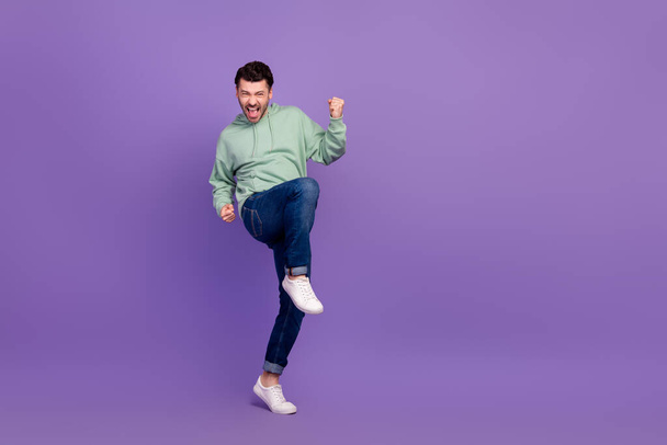 Full body size photo of young successful businessman wear stylish outfit fists up enjoy crazy empty space new tournament isolated on violet color background. - Fotó, kép