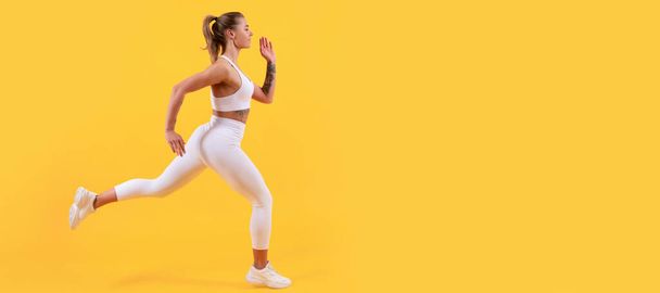 actieve sport vrouw loper draait op gele achtergrond. Vrouw springende banner met mock up copyspace - Foto, afbeelding