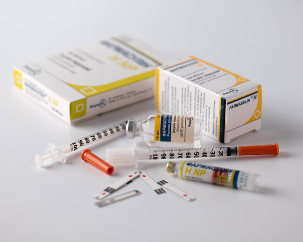 Rivne, Ukraine - July 03, 2022 - Insulin human Farmasulin 100IU / ml, for injection to diabetics, Blood sugar control, intrein syringes, white background - Фото, зображення