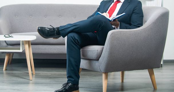pondering mature businessman in suit sit in office reading book. - 写真・画像