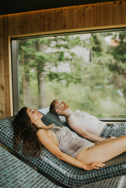Bonito casal jovem relaxante na cama de tepidário no spa - Foto, Imagem