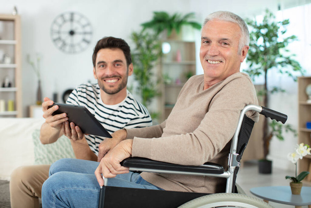 senior dad on a wheelchair and his son - Фото, изображение