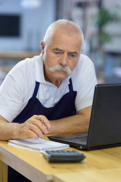 portrait of a senior man writing applications - Zdjęcie, obraz