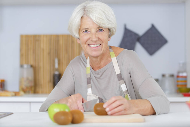 Donna che prepara l'insalata in cucina - Foto, immagini