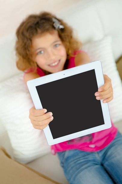 Young girl showing screen of her tablet - 写真・画像