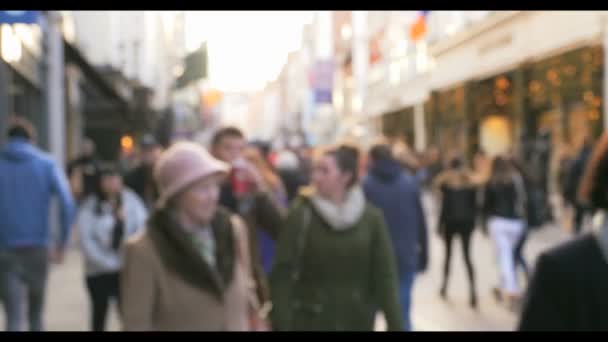 Tömeg a névtelen emberek gyaloglás, Dublin forgalmas utcában - Felvétel, videó