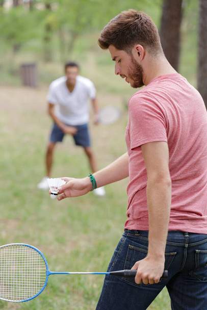 young men playing badminton outdoors - Foto, Imagen
