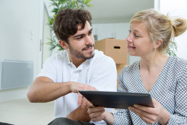 couple moving in house using a tablet - Foto, Imagem