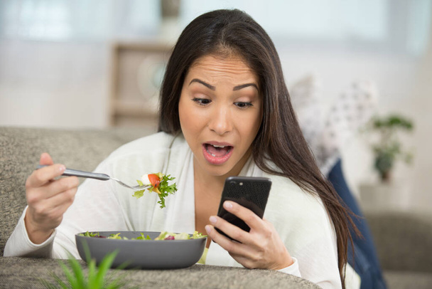 woman using cellphone and having lunch - Fotó, kép