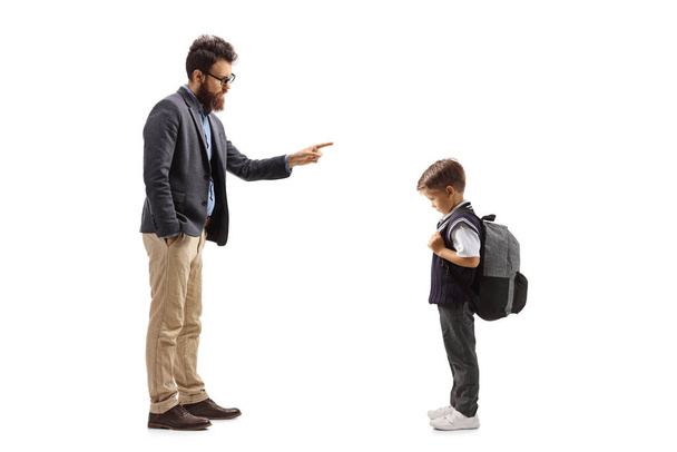 Full length shot of a man scolding a schoolboy isolated on white background - 写真・画像