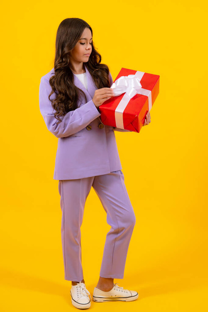 Teenager child with gift box, studio isolated background. Present for birthday, Valentines day, New Year or Christmas. Kid hold present box with gift ribbon bow - Fotó, kép