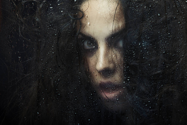Islak camın arkasındaki kadın cadı. Sanatsal renkler eklendi - Fotoğraf, Görsel