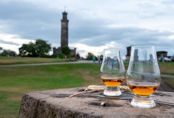 Tasting of single malt scotch whisky in glasses with panoramic view from Calton hill to new and old parts of Edinburgh city in rainy summer day, Scotland, UK - Φωτογραφία, εικόνα