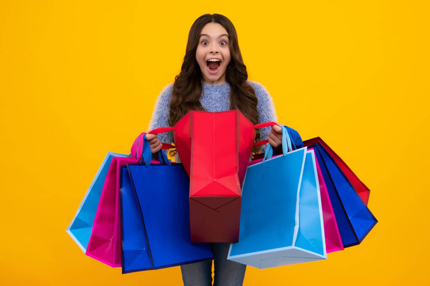 Amazed teenager. Stylish teen girl with shopping sale bags. Kid holding purchases. Excited teen girl - Fotoğraf, Görsel