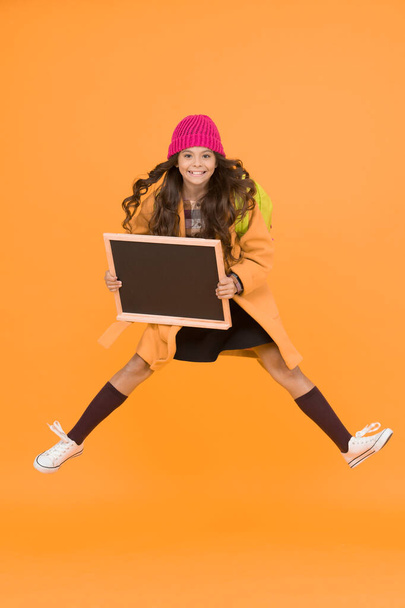 Awesome news. School schedule changes. Girl wear winter outfit blank chalkboard copy space. Fresh information. Information for children. Show information. Active jumping child excited about event. - Foto, Imagem