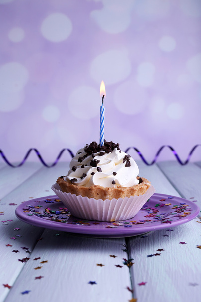 Torta tazza di compleanno con candela sul piatto sul tavolo di legno a colori e sullo sfondo chiaro
 - Foto, immagini