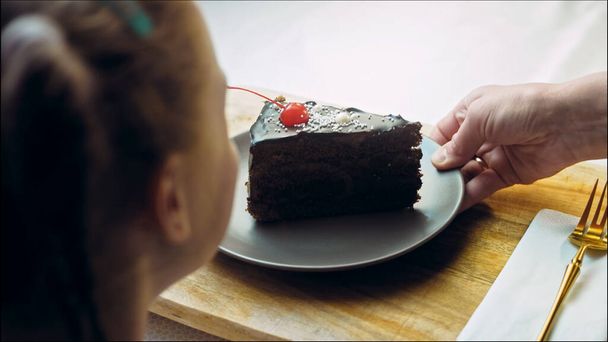 Many slices of cake on a retro-style baking sheet. The chef brings different kinds of cake to the girls tasting. The girl shows from the cape that she doesnt like the cake. - Photo, Image