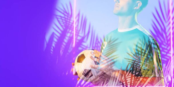 Midsection of caucasian male player holding ball over silhouette plants and illuminated rectangle. Copy space, digital composite, sport, soccer, competition, neon, illustration and abstract concept. - Foto, imagen
