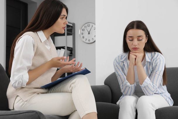Professional psychologist working with young woman in office - Zdjęcie, obraz