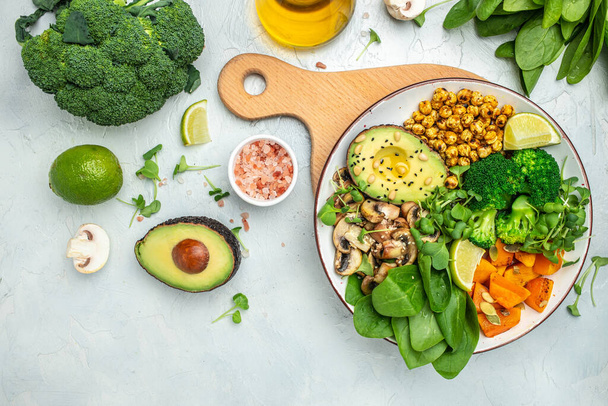 healthy vegan lunch bowl with Avocado, mushrooms, broccoli, spinach, chickpeas, pumpkin on a light background. vegetables salad. Top view. - Photo, Image