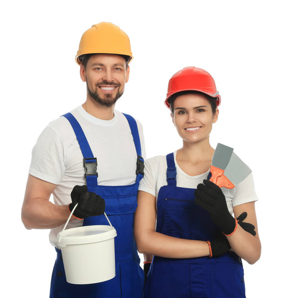 Professional workers with putty knives and plaster in hard hats on white background - Foto, imagen