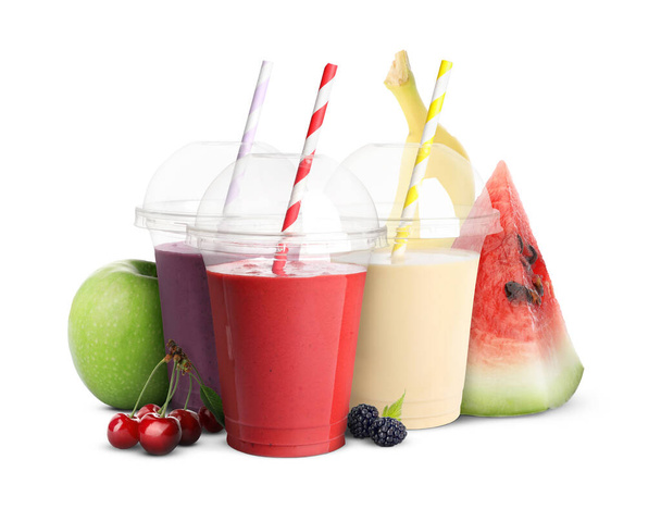 Different delicious smoothies in plastic cups on white background - Zdjęcie, obraz