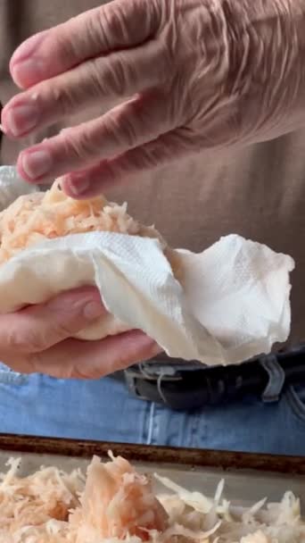 Een man perst vloeistof uit aardappelen voor het bakken - Video