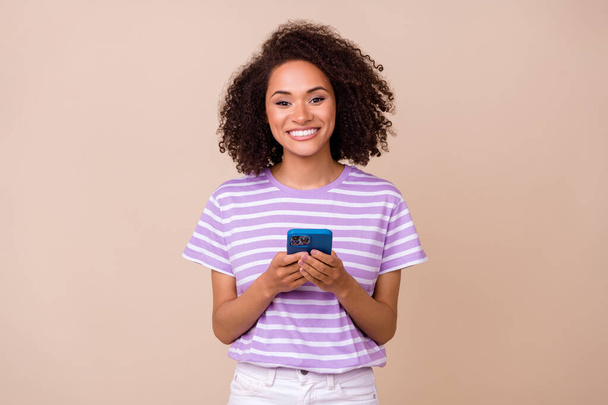 ファンキーな可愛い女性の写真は、紫のTシャツタイプinstagramのtwitter facebook現代デバイス孤立ベージュ色の背景. - 写真・画像