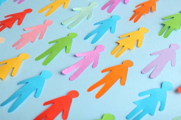 Many different paper human figures on light blue background. Diversity and inclusion concept - Фото, изображение