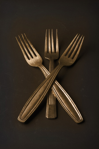 Simple still life of three gold vintage forks - Fotoğraf, Görsel
