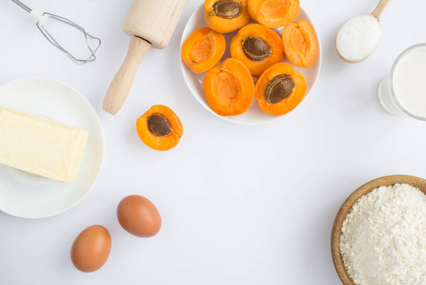 Top view of ingredients for making apricot pie or cake on the white background. Copy space. - Fotografie, Obrázek