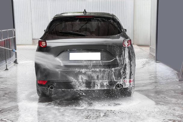 Washing auto with high pressure water jet at outdoor car wash - Valokuva, kuva