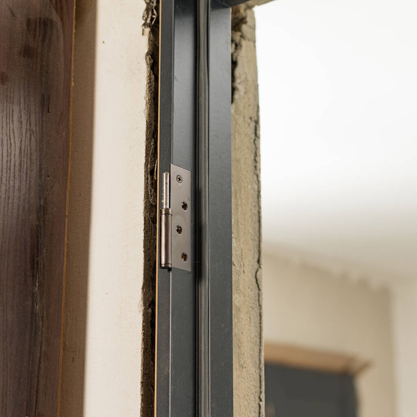 İç kapılar için paslanmaz metal menteşe, kapı kurulumu. - Fotoğraf, Görsel
