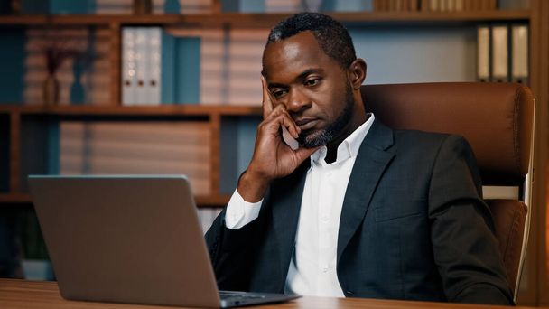 Tired sad businessman sitting in office sleepy exhausted african american male manager professional worker falls asleep at workplace napping leaning on arm feeling fatigue exhaustion from overwork - Zdjęcie, obraz