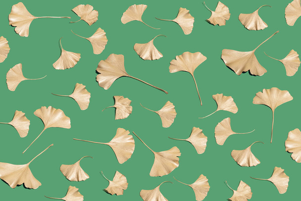 Creative layout of golden Ginkgo biloba leaves on dark green background. Neutral herbal or alternative medicine concept. - Foto, afbeelding