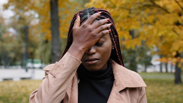 若い苦しんでいるアフリカ系アメリカ人女性が原因でミスに恥で頭の上に手のひらを置きますフラストレーションの少女は、手で顔をカバーストレス不満女性の経験の問題から恥じている - 写真・画像