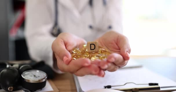 Капсулы витамина D в руках врача, крупным планом, поверхностным фокусом. Питание, пищевая добавка - Кадры, видео
