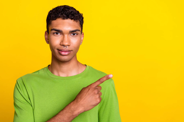 Photo portrait of attractive confident young man point empty space recommend wear stylish green clothes isolated on yellow color background. - Photo, Image