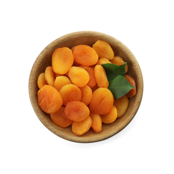 Wooden bowl with dried tasty apricots isolated on white, top view - Photo, Image
