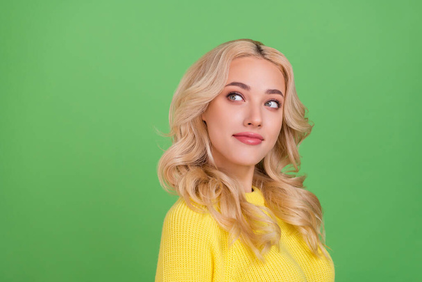 Photo of thinking millennial blond lady look empty space wear yellow pullover isolated on green color background. - Fotografie, Obrázek