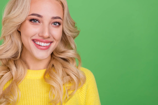 Cropped photo of cute young blond lady near promo wear yellow sweater isolated on green color background. - Zdjęcie, obraz