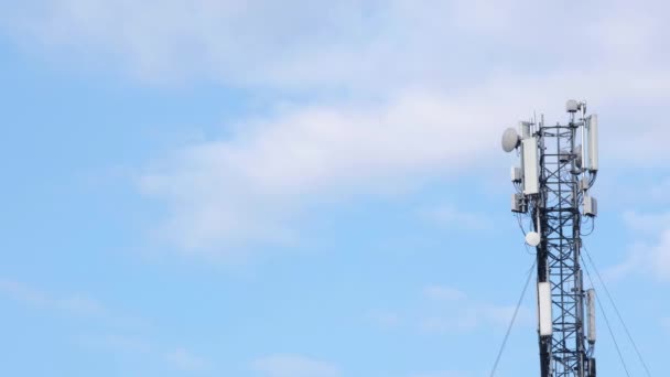 Antena do site celular em um céu azul e fundo de nuvens brancas. Torre celular com equipamento de telecomunicações móveis. Estação base de torre celular com equipamento de comunicações eletrônicas. Lugar para texto - Filmagem, Vídeo