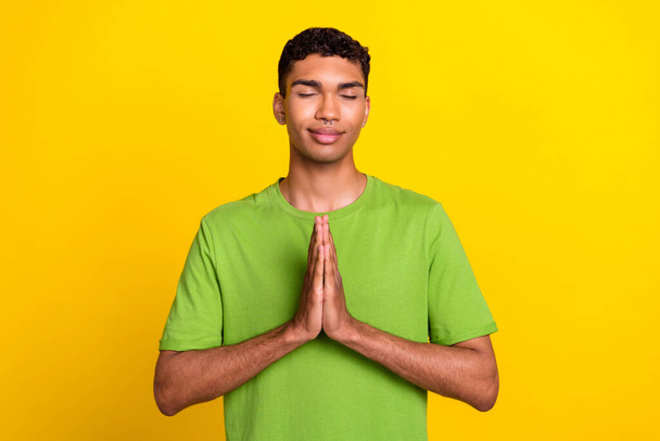 Photo of young attractive gorgeous nice positive guy closed eyes dreamy folded palms meditation help isolated on yellow color background. - Fotografie, Obrázek