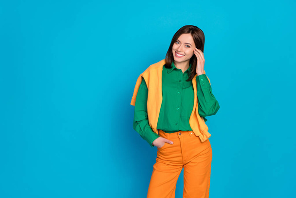 Photo of nice good looking lady dressed fashionable modern outfit orange sweater shoulders empty space isolated on blue color background. - Фото, изображение