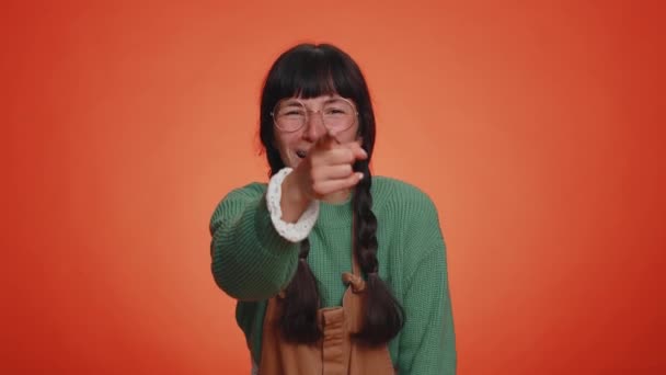 Junge Nerd-Frau mit Zöpfen in Brille, die laut lacht, nachdem sie lächerliche Anekdoten, lustige Witze hört, sich unbeschwert amüsiert, positive Menschen im Lebensstil. Latin Mädchen isoliert auf orangefarbenem Hintergrund - Filmmaterial, Video