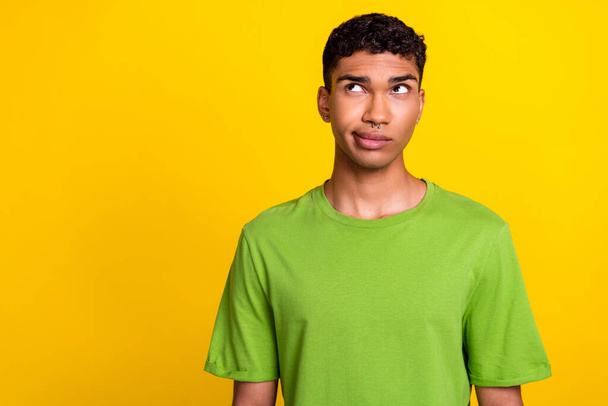 Photo of minded doubtful person look interested empty space hesitate isolated on yellow color background. - Photo, image