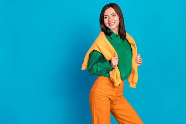 Photo of lovely lady stand empty dressed orange green cozy clothes ready walk outside good mood weather isolated on blue color background. - Фото, изображение
