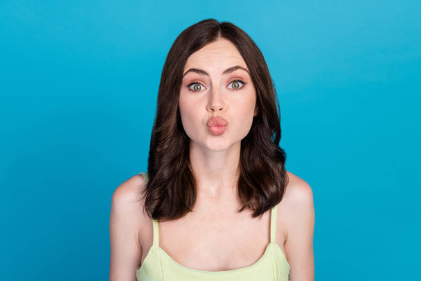 Photo of charming adorable lady wear green singlet sending you kiss isolated blue color background. - Фото, зображення