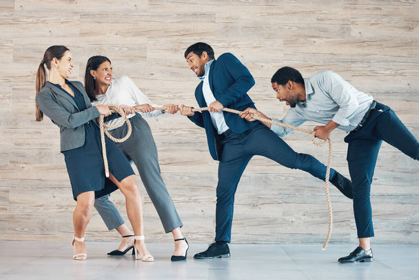 Never underestimate the power of women in business. Full length shot of a diverse group of businesspeople standing in the office together and tugging at rope - Foto, afbeelding