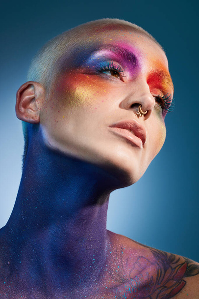 Sei der Regenbogen. Studioaufnahme einer jungen Frau, die mit mehrfarbiger Farbe im Gesicht posiert - Foto, Bild